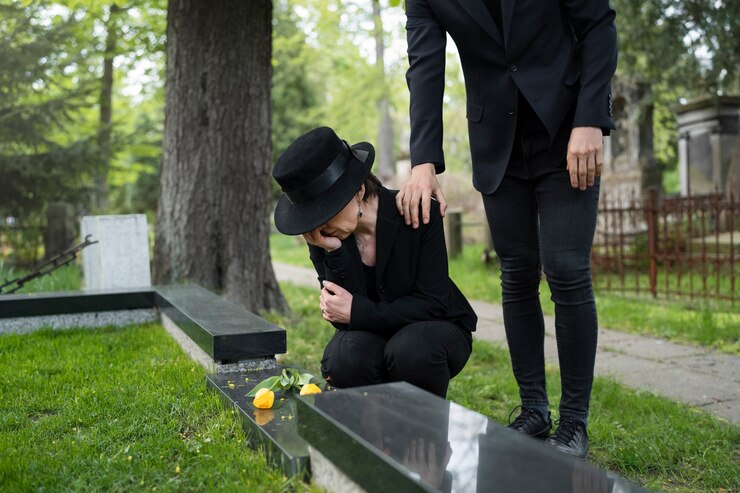 mourning-woman-cemetery-being-consoled-by-man_23-2149435529