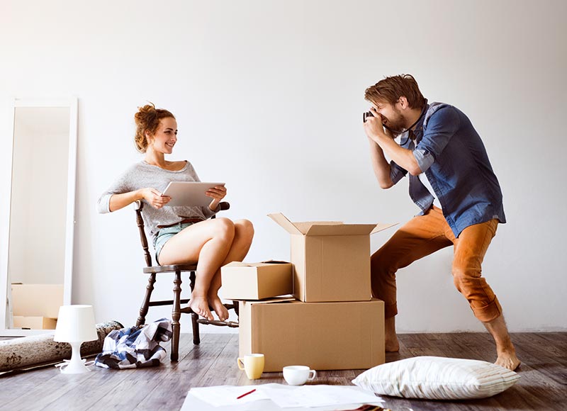 young-couple-moving-in-new-house-taking-photos-PD4QPZ5