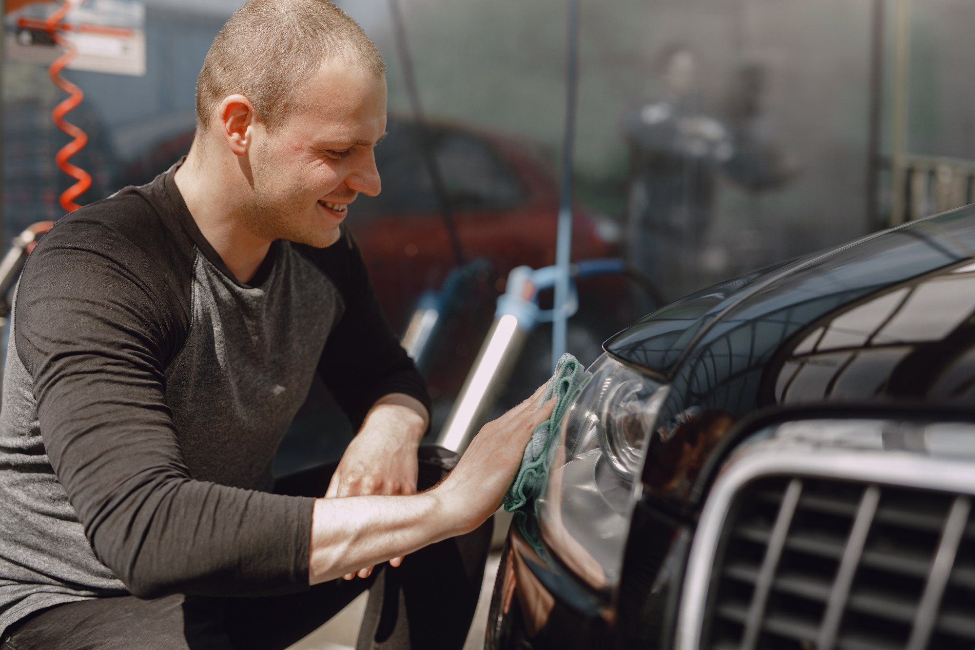 man-gray-sweater-wipes-car-car-wash