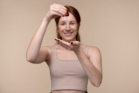 portrait-young-woman-pouring-serum-her-hand_23-2149259914